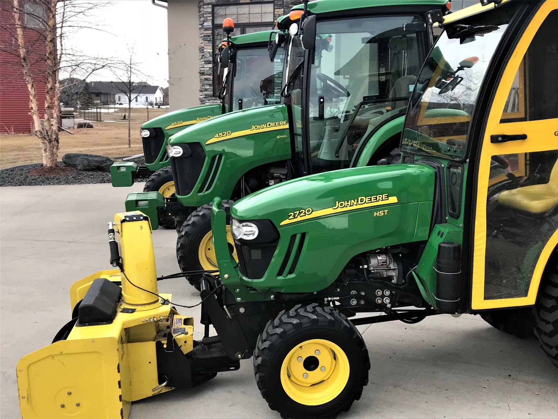 The Baker Snow & Ice fleet of John Deere tractors fitted with inverted snowblowers